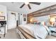 Comfortable bedroom with a rustic wood accent wall, a bed with storage and bedside tables with lamps at 12280 Golden Wreath Rd # 3, Las Vegas, NV 89183
