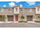 Exterior view of a modern townhome with attached two-car garage and manicured landscaping at 12280 Golden Wreath Rd # 3, Las Vegas, NV 89183