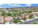 Wide aerial view of a residential neighborhood with lush landscaping and scenic mountain views in the distance at 1324 European Dr, Henderson, NV 89052