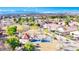 Beautiful aerial view of a community park featuring a playground, picnic area, and walking trails, with city views beyond at 1324 European Dr, Henderson, NV 89052
