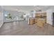 Open-concept living room and kitchen featuring wood flooring, bright windows and modern appliances at 1324 European Dr, Henderson, NV 89052