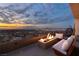 Cozy balcony with a fire pit and comfortable seating, offering a stunning sunset view of the city skyline at 1491 Reims Dr, Henderson, NV 89012