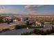 Stunning modern home exterior boasts mountain views and a landscaped driveway, with city lights on the horizon at 1491 Reims Dr, Henderson, NV 89012