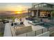Beautiful outdoor living space with a pool, fire pit, lounge area, and views of the surrounding landscape at sunset at 1491 Reims Dr, Henderson, NV 89012
