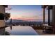 Infinity pool with a view of the Las Vegas skyline, with outdoor seating and a modern exterior design at 1491 Reims Dr, Henderson, NV 89012
