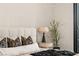 A close up of a well lit main bedroom features minimalist decor, potted plant and a stylish bedside lamp at 1491 Reims Dr, Henderson, NV 89012