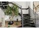 Modern staircase featuring sleek railings, dark wood stairs and a decorative tree at 1491 Reims Dr, Henderson, NV 89012