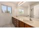 Bathroom featuring a double sink vanity, large mirror, and bright window at 1798 Lakewood Dr, Henderson, NV 89012