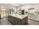 Modern kitchen with a central island and sliding glass doors to the outdoor space at 1798 Lakewood Dr, Henderson, NV 89012
