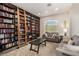 Inviting living room featuring floor-to-ceiling bookshelves with a rolling ladder and comfortable seating at 1798 Lakewood Dr, Henderson, NV 89012
