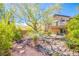 Lush backyard oasis showcasing desert-friendly landscaping, river rock, and a second-story balcony at 1844 Ghost Trace Ave, Las Vegas, NV 89183