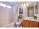 Well-lit bathroom with a combined tub and shower, a single sink, and a linen closet at 1844 Ghost Trace Ave, Las Vegas, NV 89183