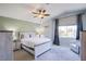 Inviting bedroom with a ceiling fan, large window, and soothing neutral tones at 1844 Ghost Trace Ave, Las Vegas, NV 89183