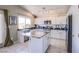 Bright kitchen features white cabinetry, an island with granite countertop, and stainless steel appliances at 1844 Ghost Trace Ave, Las Vegas, NV 89183