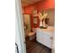 Modern bathroom with a stand-up shower, vanity, and decorative accents against a terracotta accent wall at 1900 Arietta Vista St, Henderson, NV 89044
