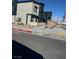 Modern two-story home displaying a contemporary facade, minimalist landscaping, and adjacent street view under a blue sky at 1900 Arietta Vista St, Henderson, NV 89044