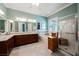 A well-lit bathroom featuring a vanity with double sinks, a soaking tub, and a glass-enclosed shower at 2080 Powder Springs St, Henderson, NV 89052
