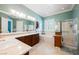 A well-lit bathroom featuring a vanity with double sinks, a soaking tub, and a glass-enclosed shower at 2080 Powder Springs St, Henderson, NV 89052