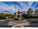 Elegant clubhouse entrance featuring well-maintained landscaping, decorative flags, and a circular driveway at 2080 Powder Springs St, Henderson, NV 89052