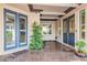 Covered entrance patio with double doors, transom windows, potted plants and tile floor at 2080 Powder Springs St, Henderson, NV 89052