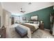 A staged primary bedroom features a king bed, bench, and artwork against green accent wall at 2080 Powder Springs St, Henderson, NV 89052