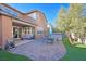 Backyard view featuring a covered patio, hot tub, patio set, grass and brick pavers at 2194 Trivero St, Henderson, NV 89044