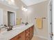 Bathroom featuring double sinks, wood cabinets, a large mirror and bronze hardware at 2194 Trivero St, Henderson, NV 89044