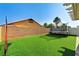 Wide shot of backyard featuring artificial grass, an outdoor play area, and a brick perimeter wall at 2531 Dollison Ave, North Las Vegas, NV 89081