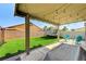 Inviting backyard featuring a covered patio, artificial grass, trampoline, and outdoor seating area at 2531 Dollison Ave, North Las Vegas, NV 89081