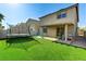 A serene backyard oasis boasting artificial turf, a covered patio, and a fun trampoline at 2531 Dollison Ave, North Las Vegas, NV 89081