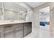 Bathroom featuring double vanity sinks, mirror, and access to Primary bedroom at 2531 Dollison Ave, North Las Vegas, NV 89081