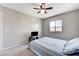 This carpeted bedroom includes a fan, window, and a bed with blue and white striped bedding at 2531 Dollison Ave, North Las Vegas, NV 89081