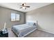 This carpeted bedroom includes a fan, window, and a bed with blue and white striped bedding at 2531 Dollison Ave, North Las Vegas, NV 89081
