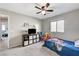 This is a carpeted bedroom with a window, a ceiling fan, and simple furniture at 2531 Dollison Ave, North Las Vegas, NV 89081