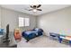 This is a carpeted bedroom with a window, a ceiling fan, and simple furniture at 2531 Dollison Ave, North Las Vegas, NV 89081