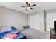 This is a carpeted bedroom with a window, a ceiling fan, and simple furniture at 2531 Dollison Ave, North Las Vegas, NV 89081