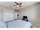 This carpeted bedroom includes a fan, closet, and a bed with blue and white striped bedding at 2531 Dollison Ave, North Las Vegas, NV 89081