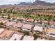 Aerial view of a desert neighborhood with terra cotta roofs, golf course, and mountain views at 2624 Spalding Dr, Las Vegas, NV 89134
