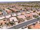 Aerial view of a desert community with tile roofs, palm trees, and desert landscaping at 2624 Spalding Dr, Las Vegas, NV 89134