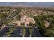 Aerial view of the community center with parking, golf course, and mountainous backdrop in a desert community at 2624 Spalding Dr, Las Vegas, NV 89134