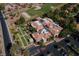 Aerial view showcases bocce ball courts and the community center, set amidst lush trees and a golf course at 2624 Spalding Dr, Las Vegas, NV 89134