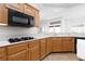 Beautiful kitchen features white countertops, an induction cooktop, and a double basin sink with oak cabinets at 2624 Spalding Dr, Las Vegas, NV 89134