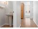 Stylish powder room with a pedestal sink, elegant fixture, and views into the hallway and living areas at 2624 Spalding Dr, Las Vegas, NV 89134