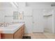 Bathroom featuring a vanity with tile countertop, large mirror and closet at 2707 Wild Breeze Ct, North Las Vegas, NV 89031