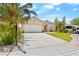 Inviting single-story home with a well-manicured lawn, complemented by a spacious driveway and desert landscaping at 2707 Wild Breeze Ct, North Las Vegas, NV 89031