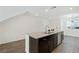 Spacious kitchen island featuring granite countertop, stainless steel sink, and dark wood cabinets at 2747 Tahiti Grape Way # 2, Las Vegas, NV 89183
