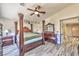 Bedroom with a poster bed, ceiling fan, ensuite bathroom, and wood-look flooring at 3525 Dover Bay St, Las Vegas, NV 89129