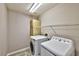 Laundry room with a front-load washer, top-load dryer, and a cabinet for storage above at 3525 Dover Bay St, Las Vegas, NV 89129