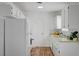 Bright kitchen featuring white cabinets, appliances, wood flooring, and a mosaic backsplash, offering a clean and updated space at 4047 Maple Hill Rd, Las Vegas, NV 89115