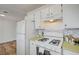 Well-lit kitchen boasts white cabinets, mosaic backsplash, and modern appliances, creating a clean and inviting space for cooking at 4047 Maple Hill Rd, Las Vegas, NV 89115